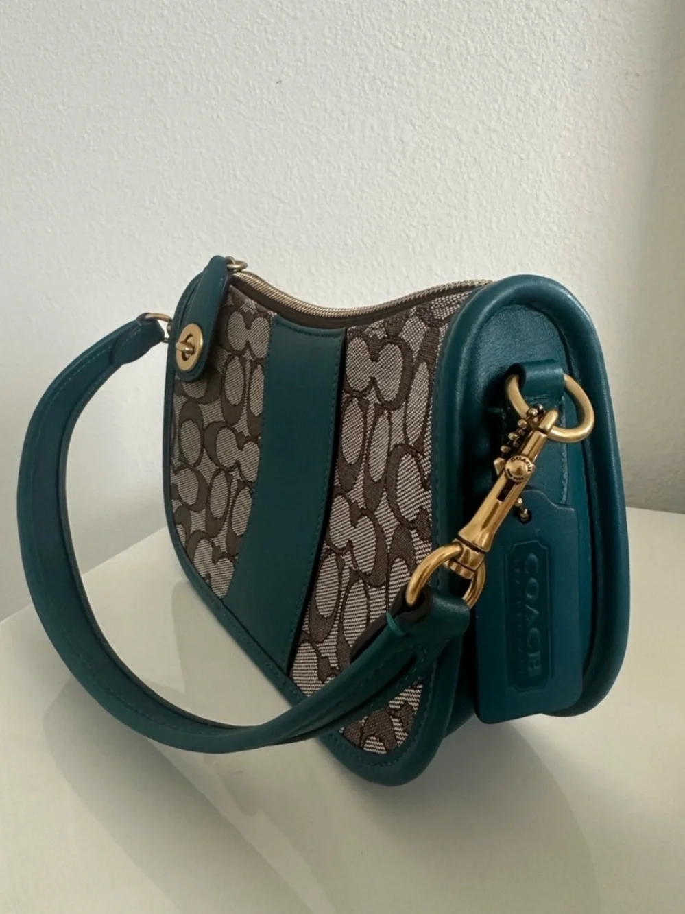 Coach Swinger in Sinature jacquard Teal soft leather and  brownSignature-Pattern